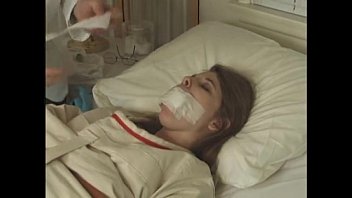 Pretty brunette in Straitjacket taped mouth forced tied to bed hospital